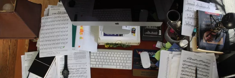 Cluttered desk with paper and computer
