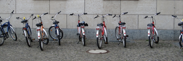 Bikes in a line Bikes lined up on the side of a building