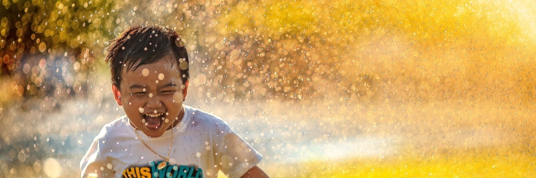 sprinkler Kid running through a sprinkler